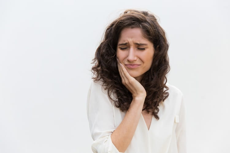a woman feeling tooth pain