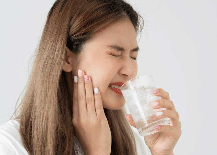 woman with sensitive tooth after drinking